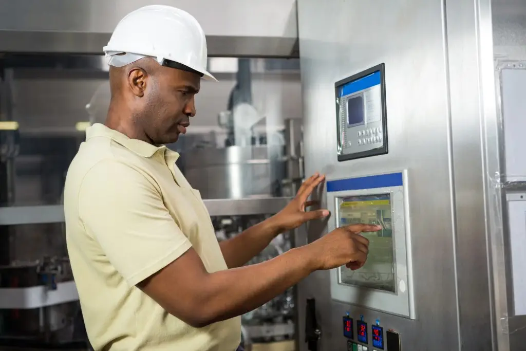 confident male employee operating machine in manufacturing industry